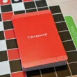 Red grammar book on a black-and-white grid background